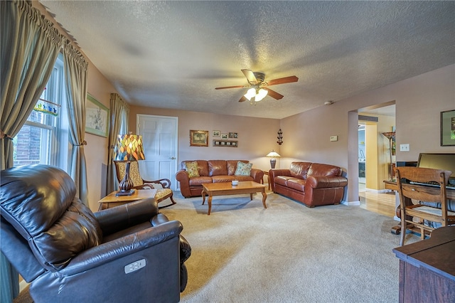 carpeted living room featuring a textured ceiling and ceiling fan