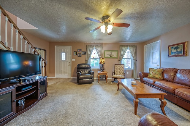 living room featuring a textured ceiling, carpet floors, and ceiling fan