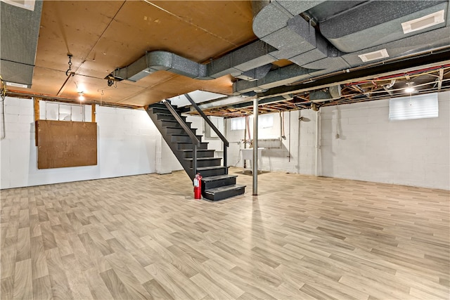 basement with light hardwood / wood-style flooring