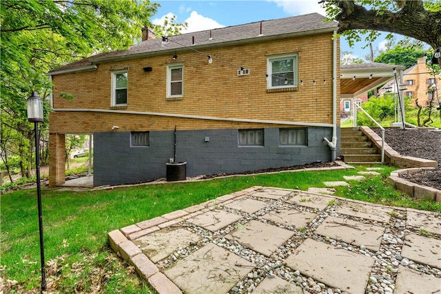 rear view of house with central air condition unit and a patio