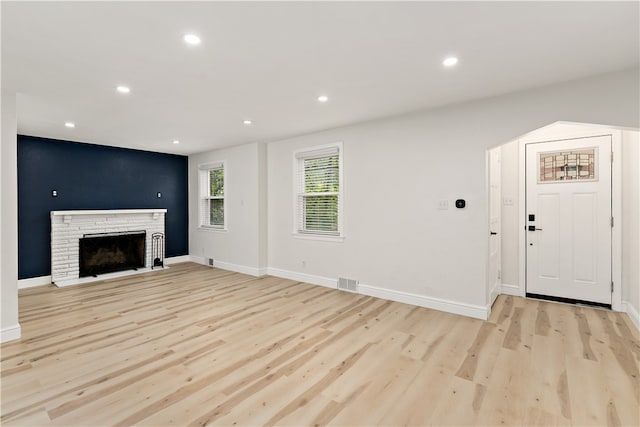 unfurnished living room featuring light hardwood / wood-style flooring and a fireplace