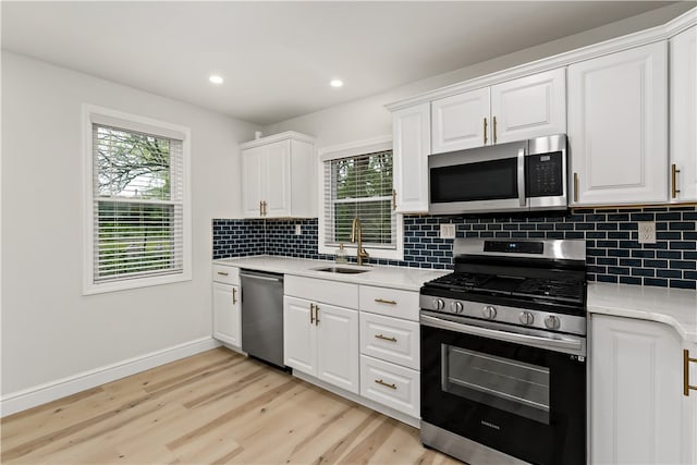 kitchen featuring plenty of natural light, stainless steel appliances, light hardwood / wood-style flooring, and sink