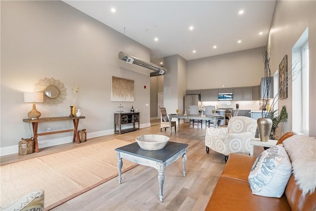 living room featuring a high ceiling and light wood-type flooring