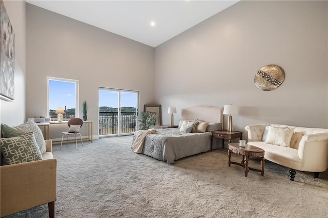 carpeted bedroom with access to exterior and high vaulted ceiling