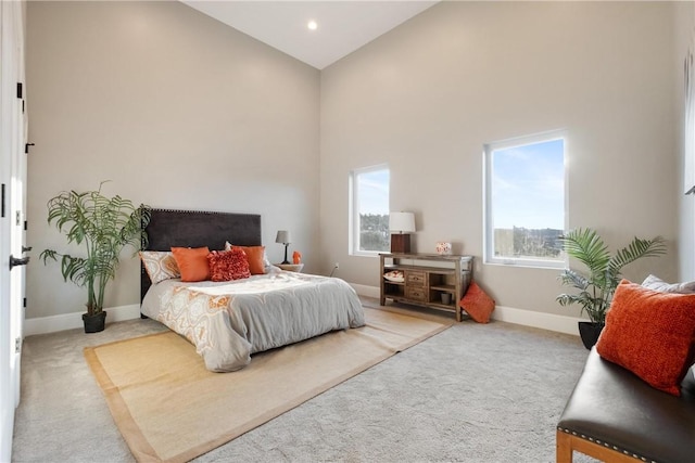 carpeted bedroom with a high ceiling