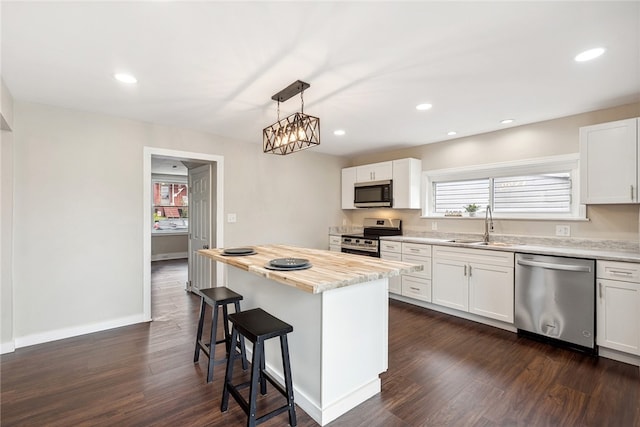 kitchen featuring appliances with stainless steel finishes, white cabinetry, and a center island