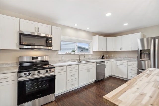 kitchen featuring appliances with stainless steel finishes, white cabinetry, and sink