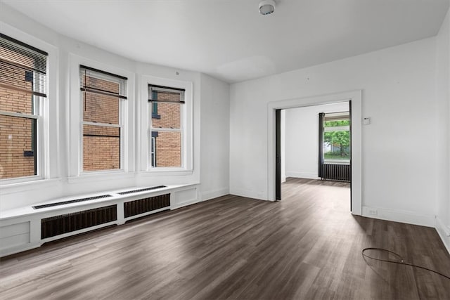 unfurnished room featuring dark hardwood / wood-style flooring and radiator