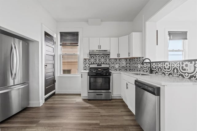 kitchen featuring white cabinets, dark hardwood / wood-style floors, stainless steel appliances, backsplash, and sink