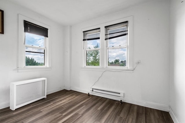 spare room with baseboard heating, plenty of natural light, radiator heating unit, and dark hardwood / wood-style flooring