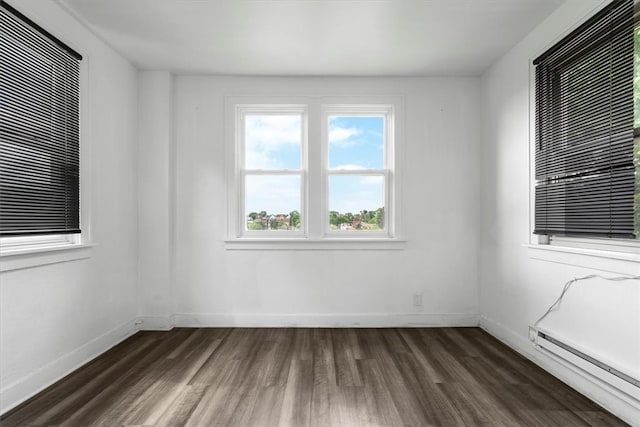 unfurnished room with a baseboard radiator and dark wood-type flooring