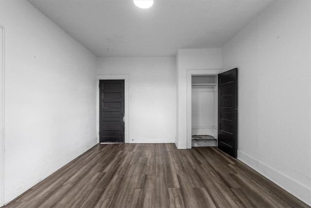 unfurnished bedroom featuring dark hardwood / wood-style floors and a closet