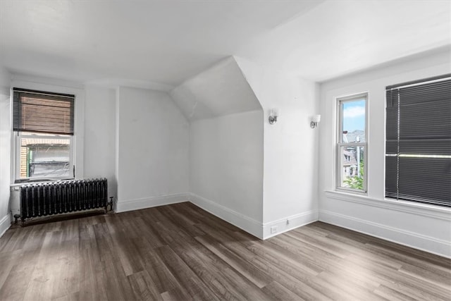 bonus room featuring radiator heating unit and hardwood / wood-style floors