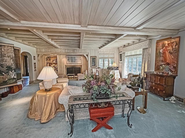 carpeted living room featuring beam ceiling