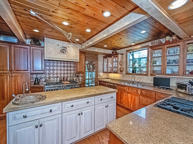 kitchen featuring beam ceiling, wooden ceiling, and light wood-type flooring