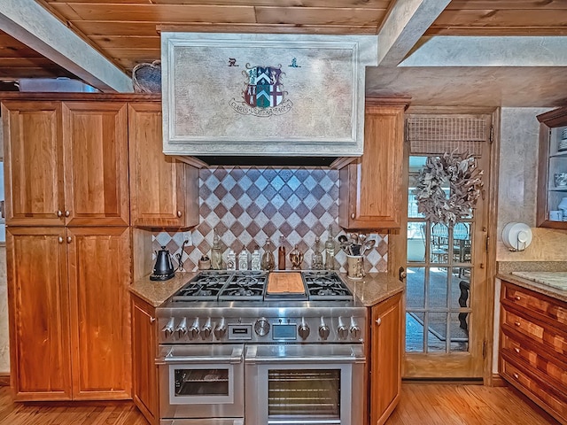 kitchen featuring double oven range, light stone countertops, light wood-type flooring, and wood ceiling