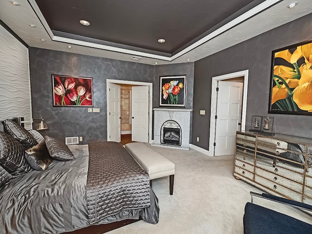 bedroom featuring a tray ceiling and carpet floors