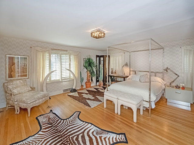 bedroom with a chandelier and light hardwood / wood-style floors