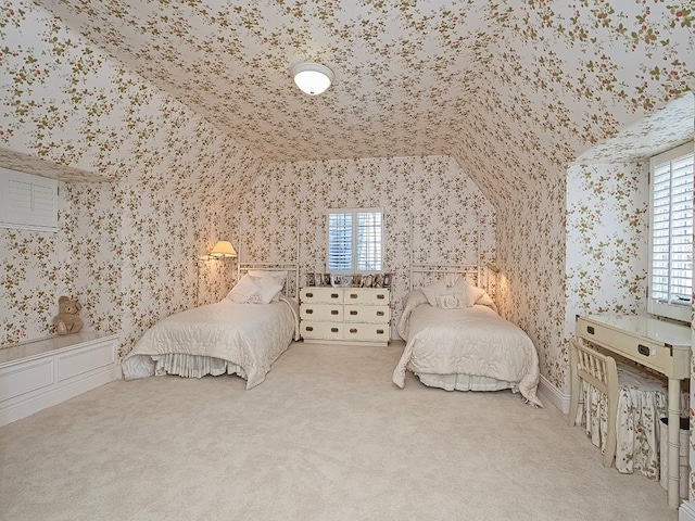 bedroom featuring multiple windows, vaulted ceiling, and carpet flooring