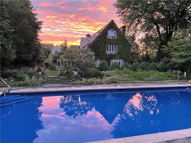 view of pool at dusk