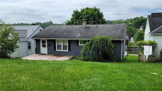 rear view of property featuring a patio and a yard