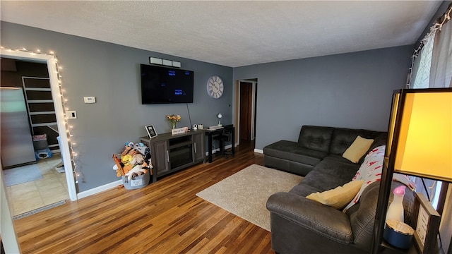 tiled living room featuring a textured ceiling