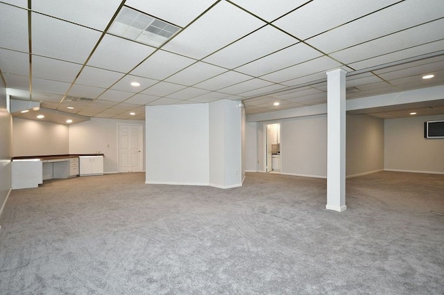 basement featuring light carpet and a drop ceiling