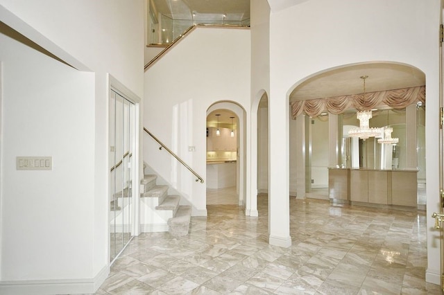 foyer entrance featuring a notable chandelier and a high ceiling