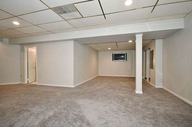 basement featuring a paneled ceiling and carpet