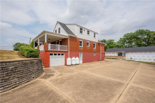 view of side of home featuring a balcony and a garage