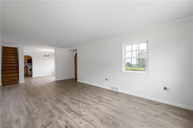 unfurnished living room with crown molding and light wood-type flooring