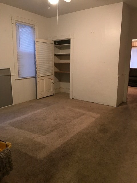 carpeted spare room featuring ceiling fan