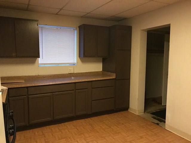 kitchen featuring a paneled ceiling and light parquet floors