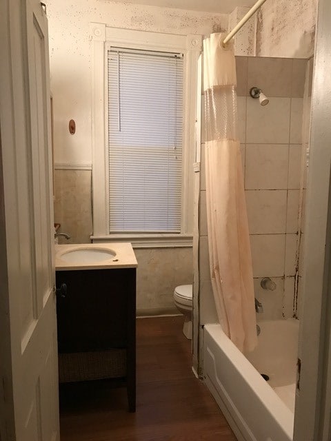 full bathroom with shower / tub combo, hardwood / wood-style flooring, toilet, and vanity