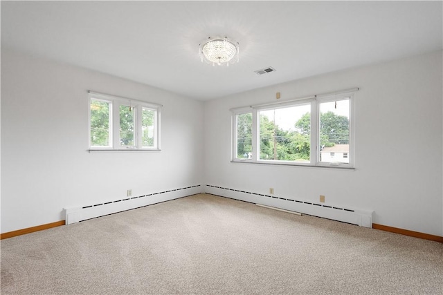 carpeted spare room with a baseboard heating unit and a wealth of natural light