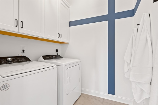 clothes washing area with cabinets, hookup for an electric dryer, light tile floors, and separate washer and dryer