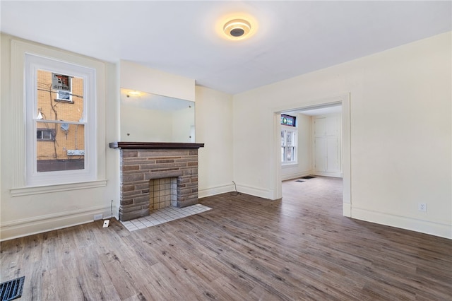 unfurnished living room featuring wood-type flooring and a fireplace