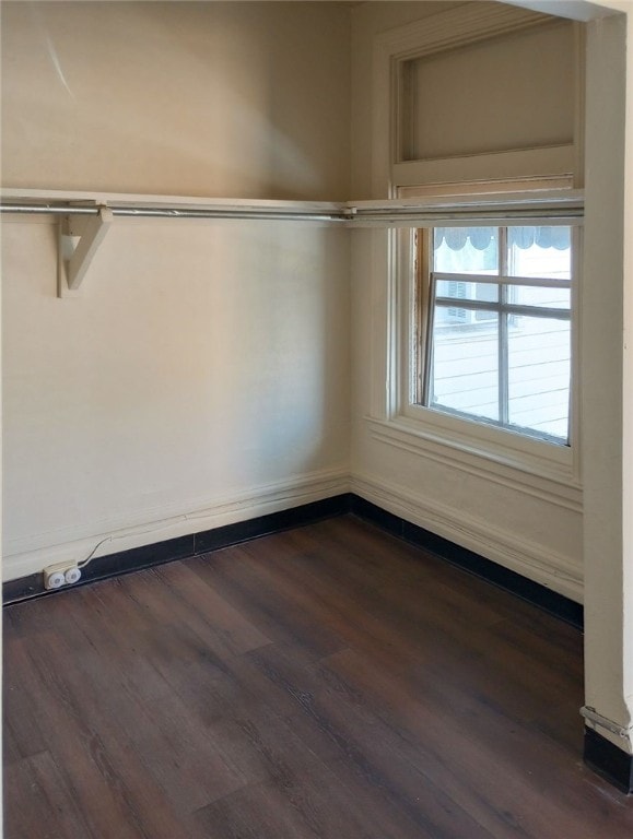 unfurnished room with dark wood-type flooring