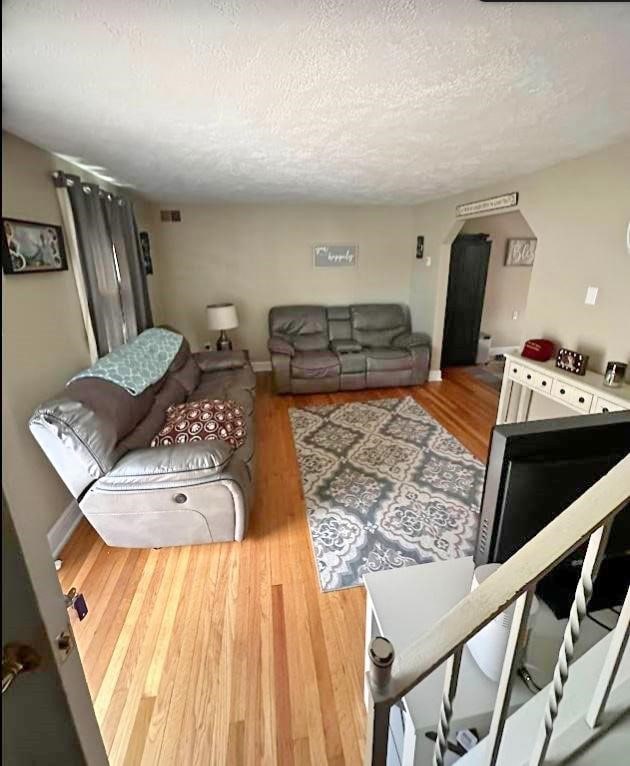 living room with hardwood / wood-style flooring and a textured ceiling