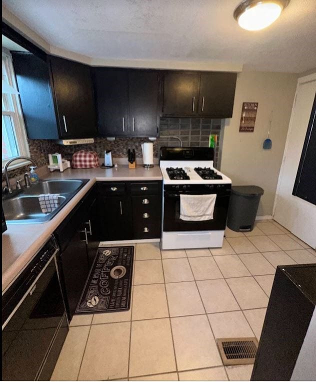 kitchen featuring sink, white gas range oven, dishwasher, and backsplash