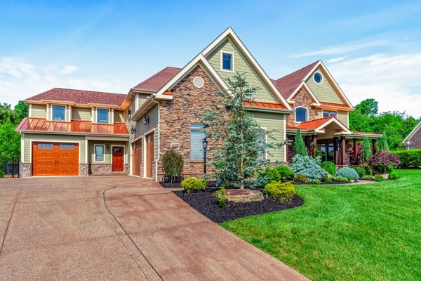 craftsman inspired home with a garage and a front lawn