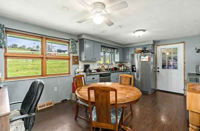 dining room featuring sink, a wealth of natural light, dark wood-type flooring, and ceiling fan