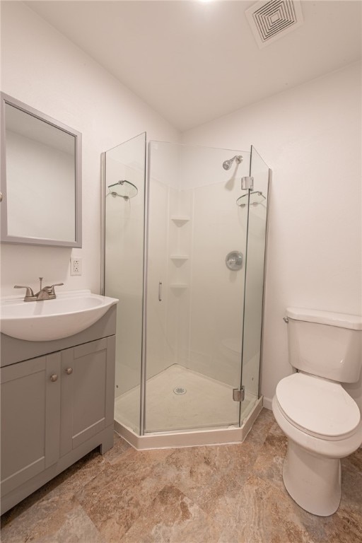 bathroom featuring vanity, toilet, and a shower with shower door