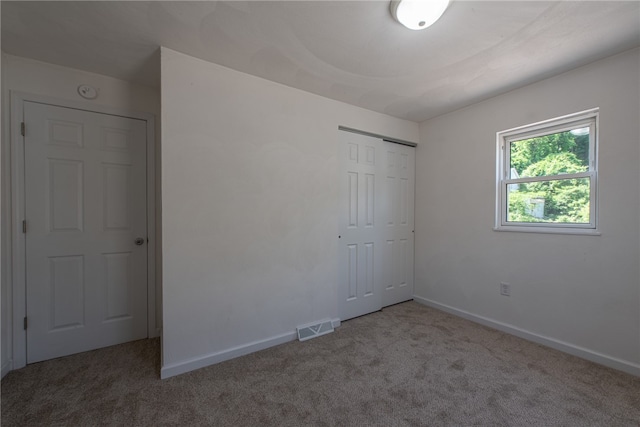 unfurnished bedroom with carpet and a closet