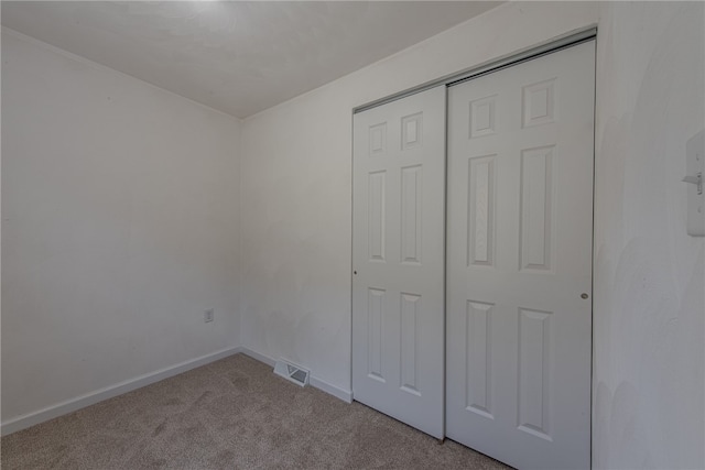 unfurnished bedroom with carpet flooring and a closet