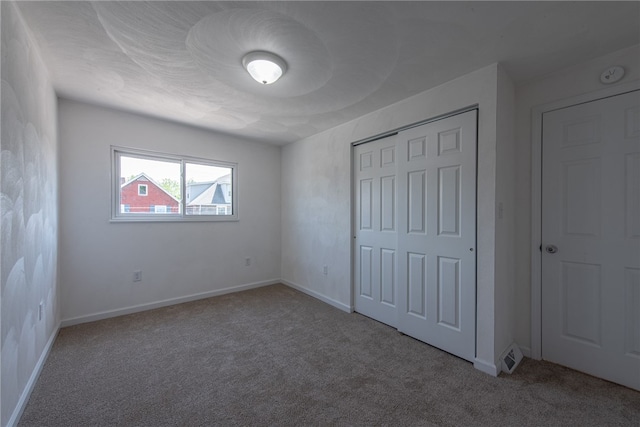 unfurnished bedroom with a closet and carpet flooring