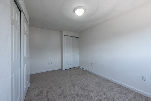 unfurnished bedroom with carpet flooring and multiple closets