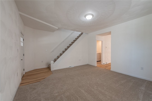 bonus room featuring light colored carpet and washer / clothes dryer