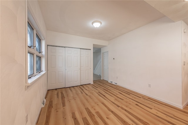 unfurnished bedroom featuring a closet and light hardwood / wood-style floors