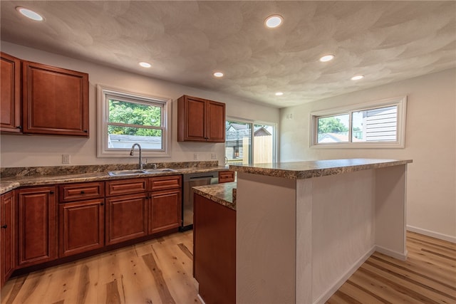 kitchen featuring dishwasher, a healthy amount of sunlight, sink, and a center island